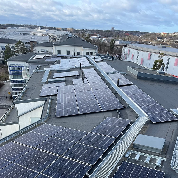 Överblicksbild på ett tak med solcellspaneler. Modern grön el.
